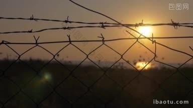 慢动作斯坦尼康拍摄的金色日落<strong>景色</strong>通过铁丝网围栏网监禁和监禁